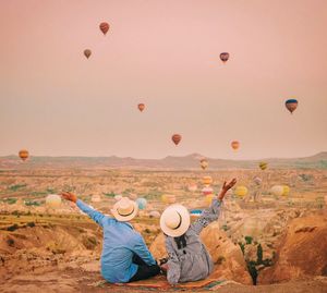 Rear view of hot air balloons flying in sky