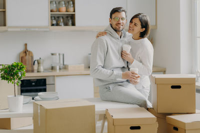 Smiling woman looking at man sitting on table