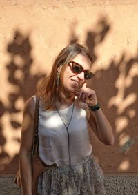 Young woman wearing sunglasses standing outdoors