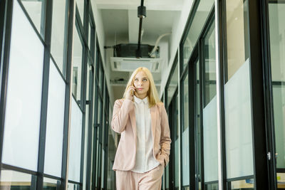 Young woman looking through window