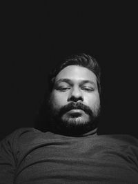 Portrait of young man against black background