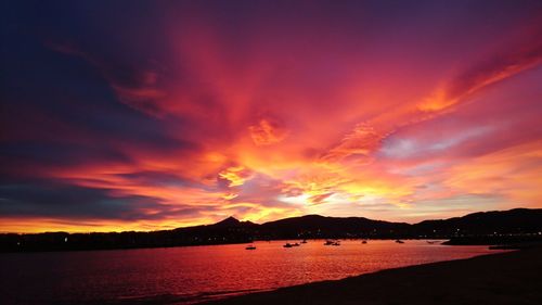 Scenic view of sea against dramatic sky during sunset