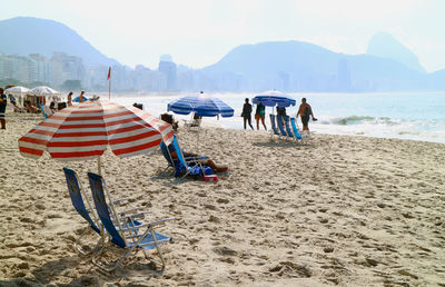 People at beach against sky