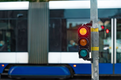 Blurred view of city traffic with traffic lights, in the foreground a semaphore with a red light