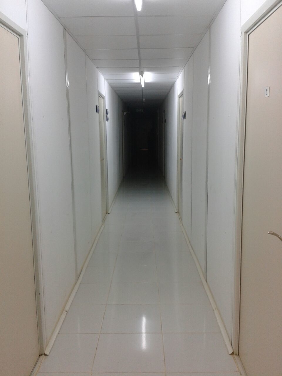 indoors, corridor, illuminated, architecture, the way forward, built structure, lighting equipment, ceiling, empty, diminishing perspective, wall - building feature, door, absence, flooring, wall, building, narrow, tiled floor, in a row, no people