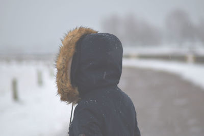 Close-up of woman on road during snowfall