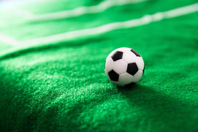 Close-up of small soccer ball on green textile