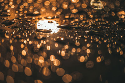 Close-up of wet illuminated car during rainy season