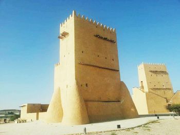 Low angle view of built structure against clear blue sky