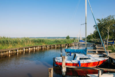 Sailboats moored on lake against clear sky