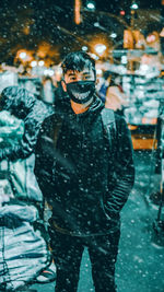 Portrait of young man standing in snow