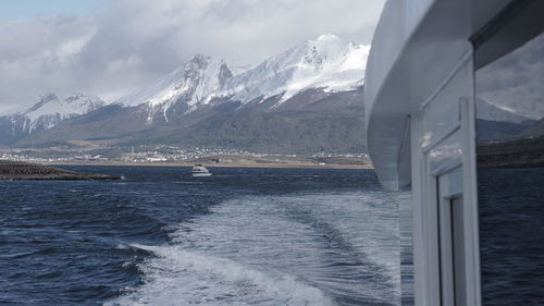 Scenic view of sea and snowcapped mountains against sky