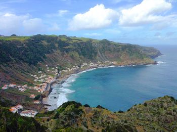 High angle view of sea and mountains against sky