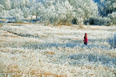 Girl standing on grassy field during winter