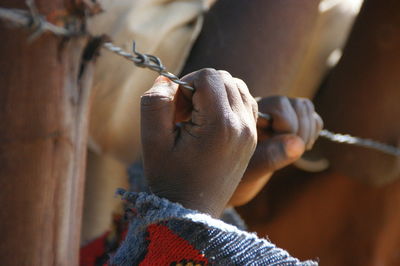 Cropped image of hands holding barbed wire