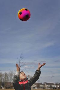 Woman with balloons against sky