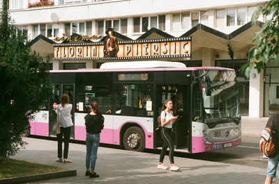 People on street against buildings in city