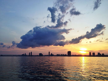 Scenic view of sea against cloudy sky during sunset