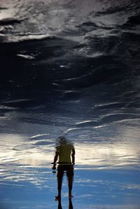 Upside down image of man reflecting in puddle