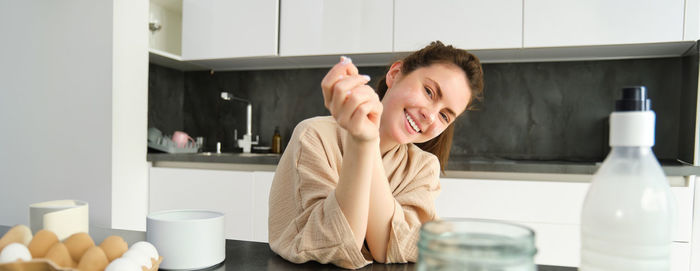 Portrait of young woman drinking coffee at home