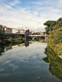 Scenic view of river by buildings against sky