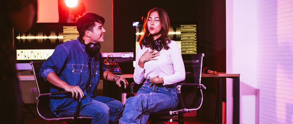 Young couple sitting in illuminated room