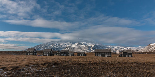 Panoramic view of buildings dwarfed by snow covered mountains in the background