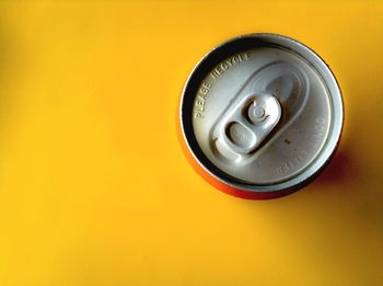 High angle view of drink can on yellow table