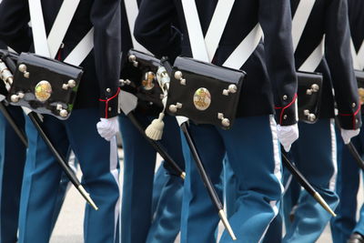 Midsection of soldiers marching on street