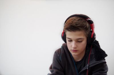 Boy listening music against white background