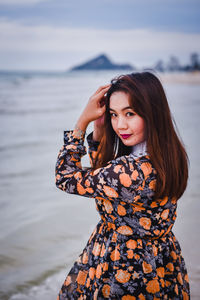 Portrait of beautiful woman standing on beach