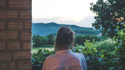 Rear view of woman standing by plants