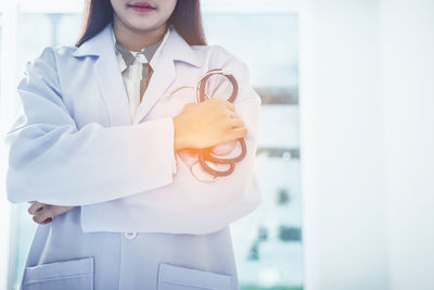 Mid section of a woman holding white flower