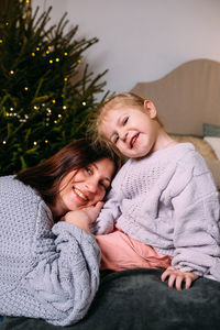 Portrait of cute girl sitting on sofa at home