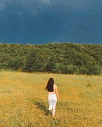 Rear view of woman standing on field