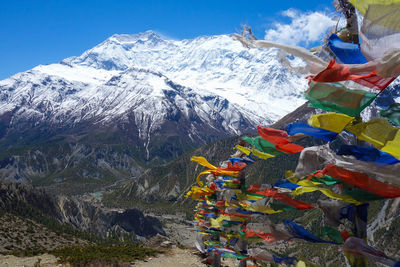 Multi colored prayer flags against snowcapped mountains