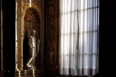 Statue against window in building