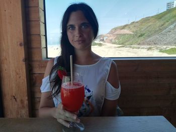 Portrait of young woman sitting on table