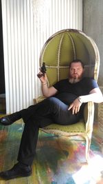 Portrait of man sitting on chair at home