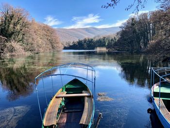 Boat moored on lake against sky