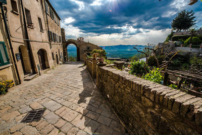 Footpath amidst buildings against sky