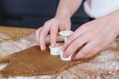 A little girl makes heart-shaped cookies from rye dough. the concept of valentine's day