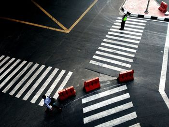High angle view of officer standing on zebra crossing at street