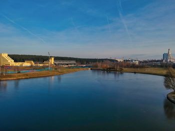 River by buildings against blue sky