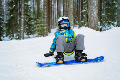 Rear view of woman skiing on snow covered field