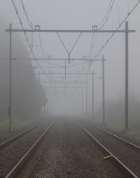 Railroad tracks against sky during foggy weather