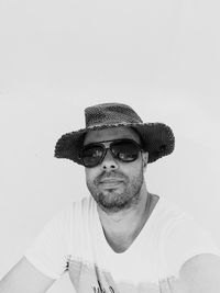 Portrait of young man wearing hat against wall