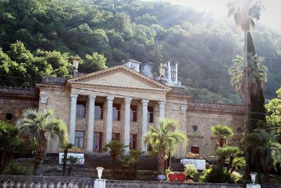 Statue by historic building against sky