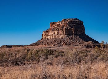 Low angle view of rock formations against clear blue sky