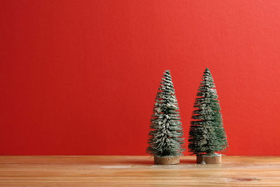 Illuminated christmas tree on red wall